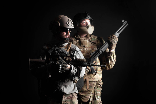 Американські спецпризначенці. Два рейнджери у формі зі зброєю стоять разом на темному тлі, портрет двох солдатів. - Фото, зображення