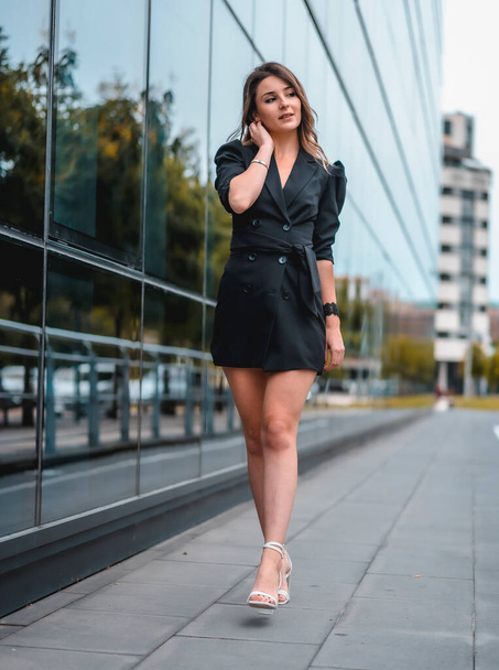 portrait of young attractive woman in stylish clothes posing in the city street - Фото, изображение