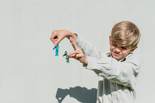 Een kleine jongen speelt en toont zijn plasticine ambachten - Foto, afbeelding