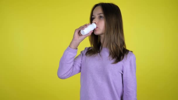 Meisje drinkt yoghurt met fles, draait zich om de camera, glimlacht en toont als - Video