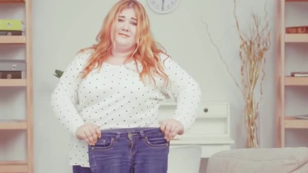 Overweight girl brought her old pair of jeans to nutritionist showing her oversized problem and consults about health issues. Healthy food concept. Tinted video. Prores 422 - Filmmaterial, Video