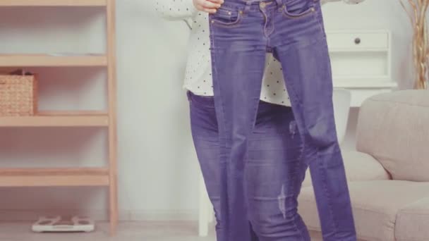 Close up. Overweight girl brought her old pair of jeans to nutritionist showing her problem and consults about health issues. Healthy food concept. Tinted video. Prores 422 - Metraje, vídeo