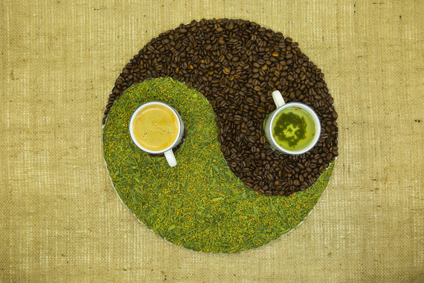 Das Konzept des Yin Yang. Zeigen Sie Yin Yang vor dem Hintergrund von Burlap. Japanischer Streichholztee mit gebratenem Reis und kubanischem Kaffee wurde verwendet. - Foto, Bild