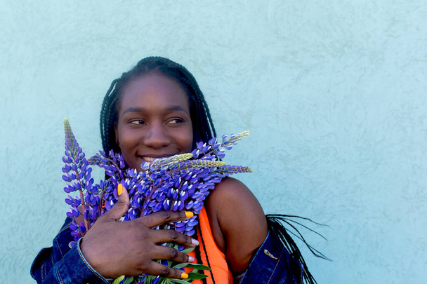 the Happy and beautiful African American with purple flowers - Photo, Image