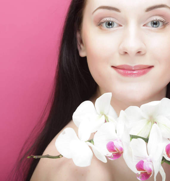 Beautiful healthy woman with orchid flower. close up - Fotó, kép