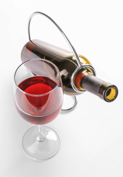 Тримач з пляшкою і келихом вина на білому тлі
 - Фото, зображення