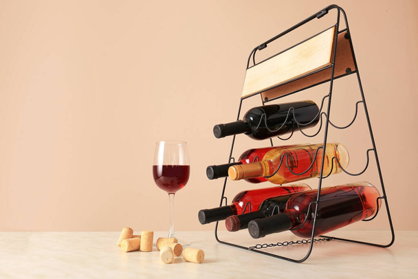 Elinde şişeler ve masada bir bardak şarap olan tutucu. - Fotoğraf, Görsel