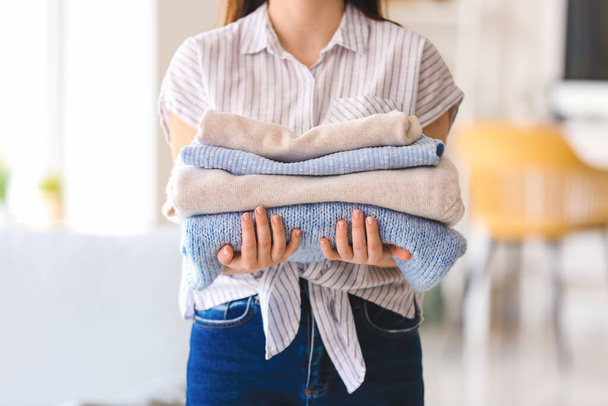 Woman with stack of clean clothes at home, closeup - Photo, Image