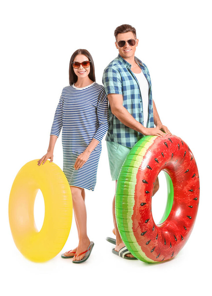 Jeune couple avec anneaux gonflables sur fond de couleur - Photo, image
