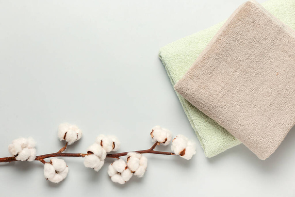 Bawełniane kwiaty i miękkie ręczniki na szarym tle - Zdjęcie, obraz