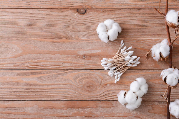 Flores de algodón con hisopos cosméticos en la mesa
 - Foto, imagen