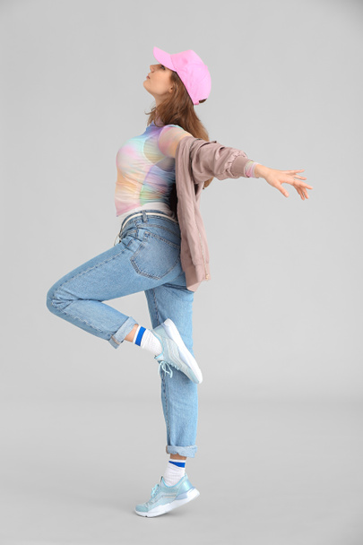 Krásná fena hip-hop tanečnice na šedém pozadí - Fotografie, Obrázek