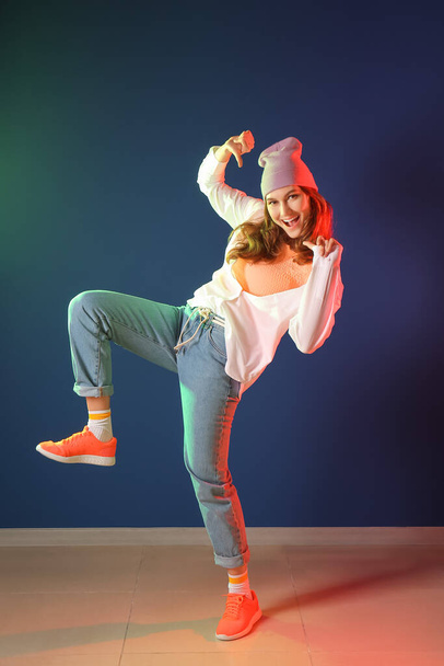 Beautiful female hip-hop dancer against color wall - Foto, Imagem