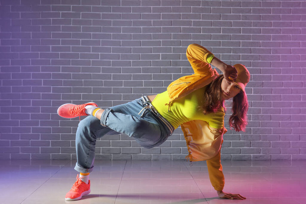 Beautiful female hip-hop dancer against brick wall - Foto, immagini