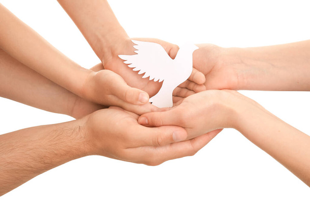 Handen van familie met papieren duif op witte achtergrond - Foto, afbeelding