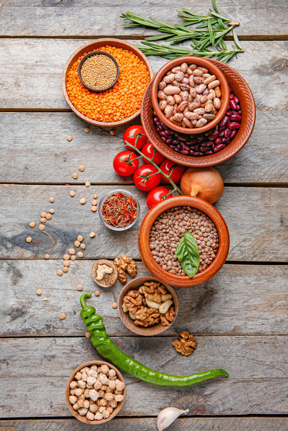 Different raw legumes with spices on table - Фото, изображение