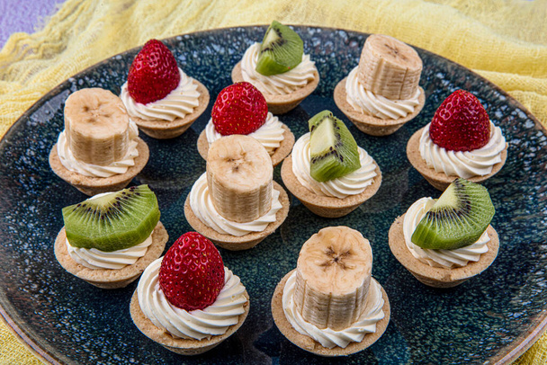 Mini tartes, tartelettes ou tartelettes à la crème et aux fruits frais
 - Photo, image