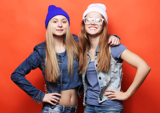 Two young girl friends standing together and having fun. - Фото, изображение