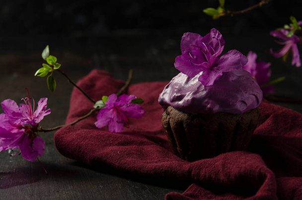 Csokoládé cupcakes cékla krém sötét alapon virág labrador tea vagy rododendron - Fotó, kép