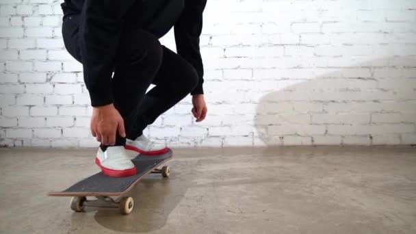 Skateboardista předvádí skateboard trik - pop shuv to na betonu. Sportovec cvičí skok na bílém pozadí, připravuje se na soutěž - Záběry, video