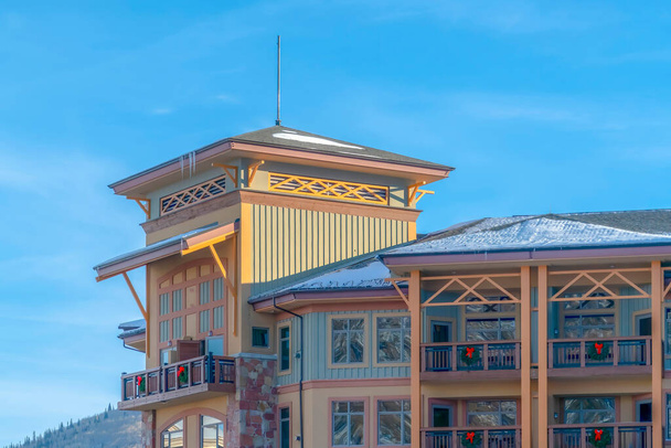 Жилое здание со снежными крышами и балконами с рождественским венком
 - Фото, изображение