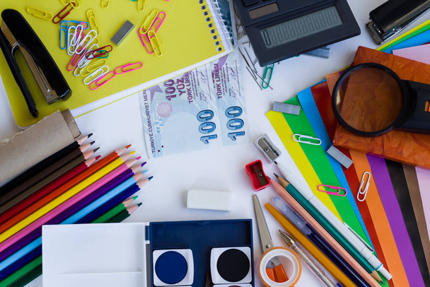 Fournitures scolaires colorées sur fond blanc avec argent turc.Concept de shopping scolaire. - Photo, image
