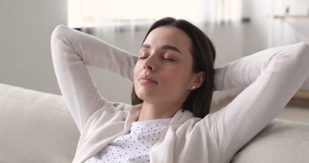 Mindful young beautiful woman meditating or daydreaming on comfortable sofa. - Filmati, video