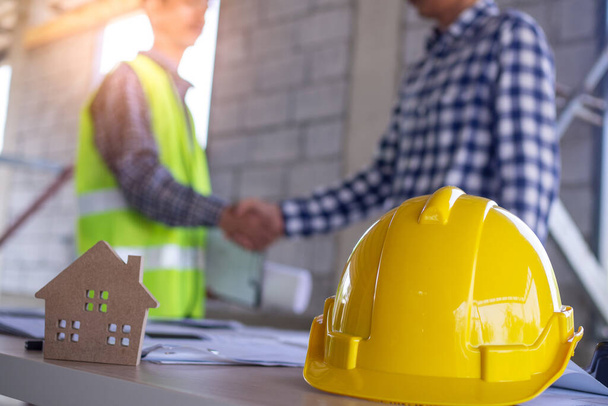 Dodavatel a inženýr potřást rukou, aby se dohodli na stavbě domu nebo budovy. Stavební dělník přijímá mzdové podmínky. Kontrola stavenišť a stavebních nebo opravárenských nákladů - Fotografie, Obrázek