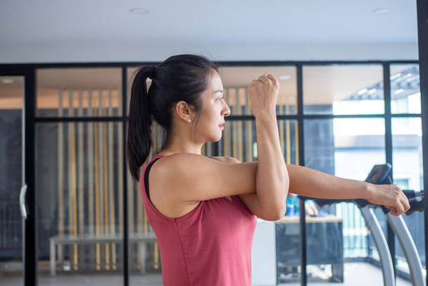 Asian women wearing sportswear standing, stretching arms, preparing muscles to stretch to prepare the body to be ready to exercise. Health and fitness concept - Photo, Image