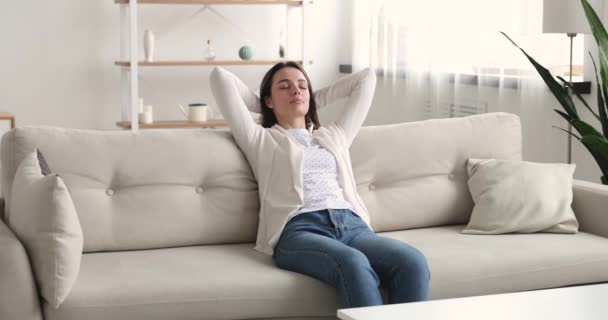 Peaceful young beautiful woman resting on comfortable couch. - Video