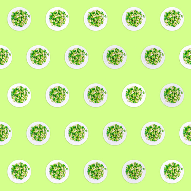 Pattern of plates with lightly fried brussels sprouts on the neon green drop - Foto, afbeelding