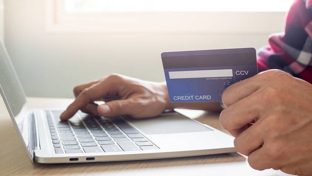 businessman hands using laptop computer for online shopping at home. Hand holding credit card with payment detail page display and credit card, Online shopping and stay home concepts. - Fotó, kép