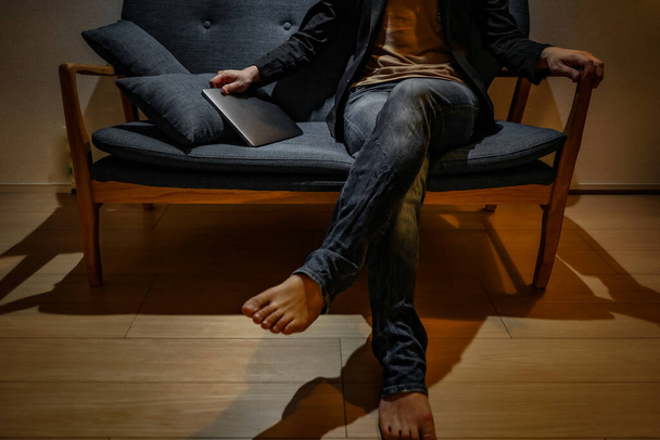 Homens sentam-se no sofá da moda
 - Foto, Imagem
