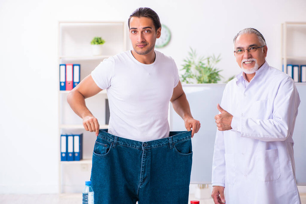 Médecin diététicien et patient heureux portant un pantalon large
 - Photo, image