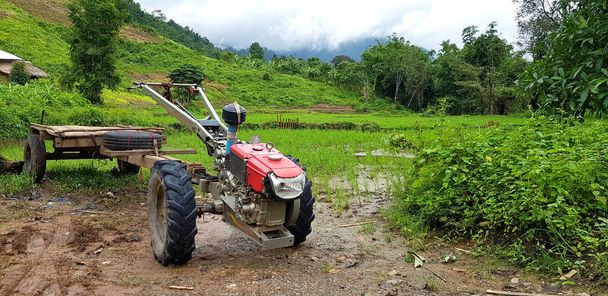 Red E-taen Thajský traktor modifikuje na použití pro raketoplán a vyzvednout nebo vysadit lidi zaparkované na bahnité zemi s kopírovacím prostorem a zelené hory, stromy a nebe pro pozadí. - Fotografie, Obrázek