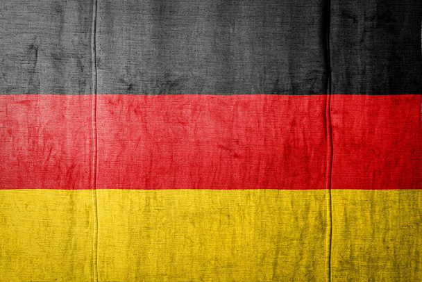 Εθνική σημαία της Γερμανίας απεικονίζει σε χρώματα χρώμα σε παλιά κλωστοϋφαντουργικά προϊόντα. Σημαία σε φόντο υφάσματος. - Φωτογραφία, εικόνα
