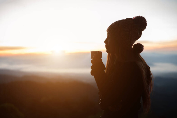Νεαρή γυναίκα απολαμβάνει καφέ έξω με όμορφη θέα στα βουνά  - Φωτογραφία, εικόνα