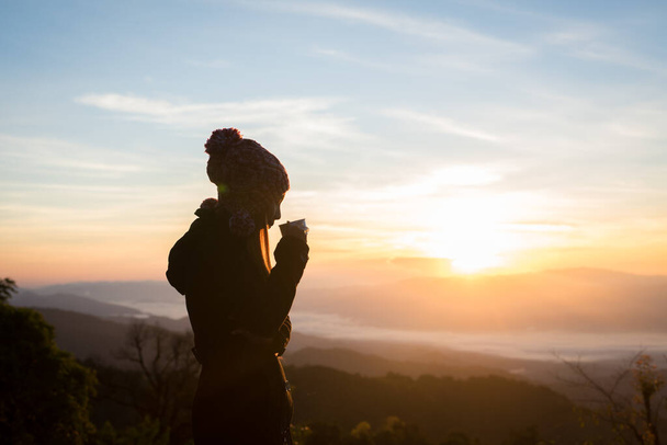 Fiatal nő élvezi a kávét kívül gyönyörű kilátás nyílik a hegyekre  - Fotó, kép