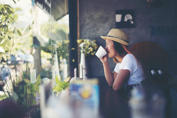 Schöne süße Mädchen im Café am Fenster mit Kaffee lächelnd - Foto, Bild
