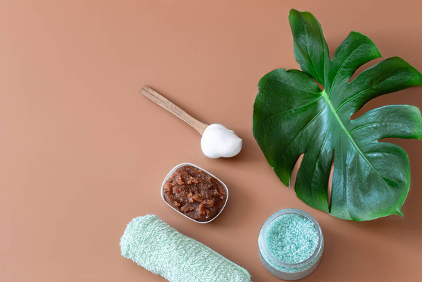 Spa composition with body care items on a colored background with a Monstera leaf . Spa concept. - Foto, afbeelding