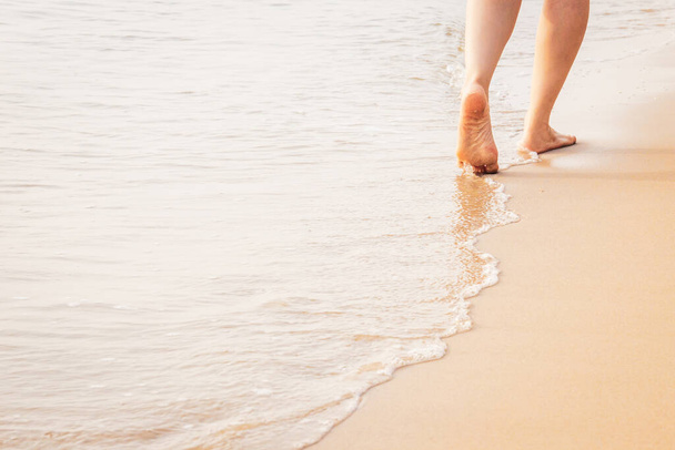 Boldog nő, aki hosszú sétákat tesz reggel a parton. Lábnyomok vagy lábnyomok a homokon, közel a fénymásoló helyhez. Wellness és szellemi az egészséges nyugdíjasok tartózkodása alatt a természetben. - Fotó, kép