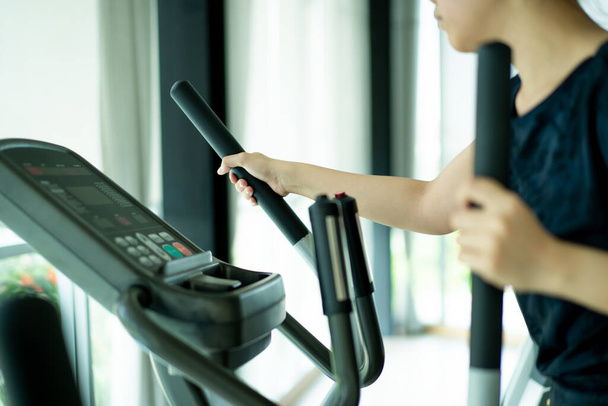 Asian fat woman using exercise machines in indoor gym, sport Asian woman's portrait with copy space. - Photo, image