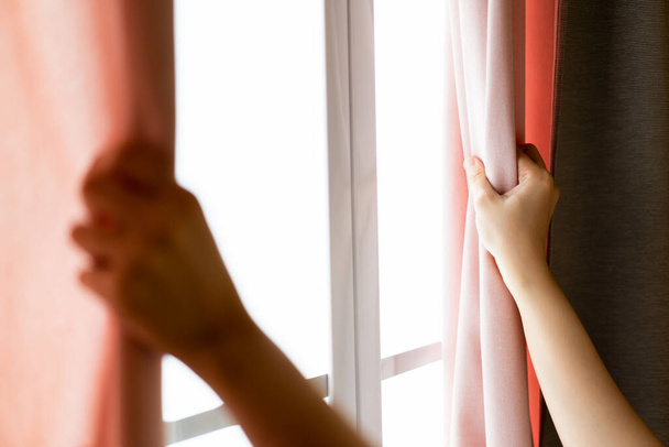 Happy Beautiful young Asian woman opening window curtain in the morning. Portrait of Pretty Asian young woman looking the sun rise outside through the window peacefully, Asian girl portrait close up. - Foto, Imagem
