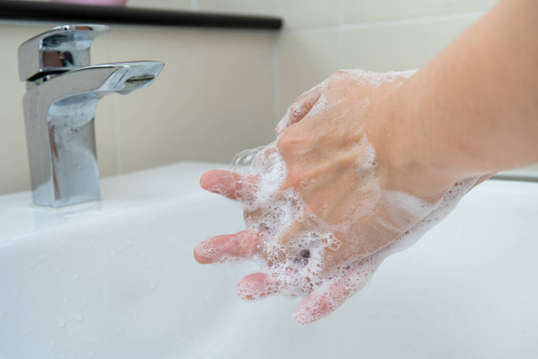 Woman washing her hands by using liquid hand washer soap for protecting from coronavirus 2019, COVID-19 virus inflection risk. Washing a hands can increase personal hygiene and protect from virus. - Фото, изображение
