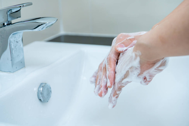 Nő mossa a kezét folyékony kézmosó szappannal a koronavírus 2019 elleni védelemhez, COVID-19 vírusfertőzés kockázata. A kézmosás növelheti a személyes higiéniát és védelmet nyújthat a vírussal szemben. - Fotó, kép