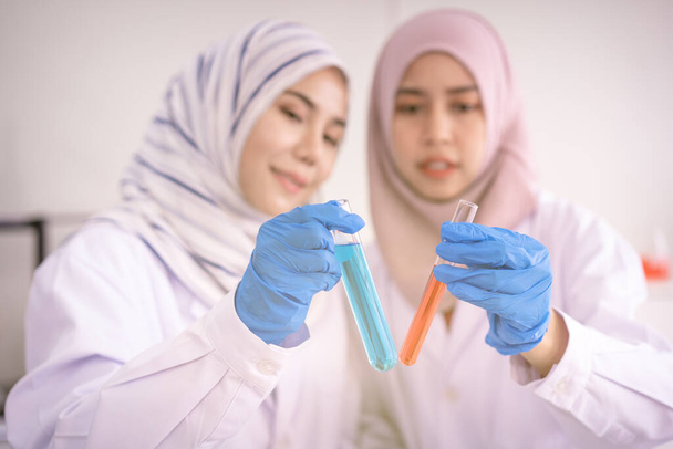 Investigadoras musulmanas haciendo el experimento en el laboratorio de química
. - Foto, Imagen