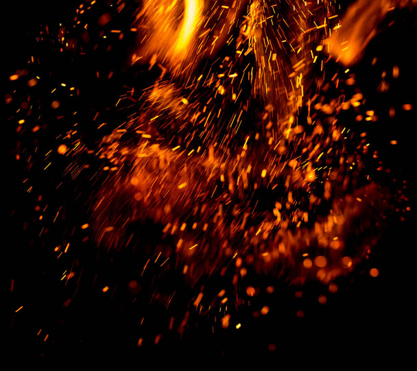 Feuerflamme mit Funken auf schwarzem Hintergrund - Foto, Bild