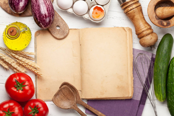 Μαγειρικά σκεύη και υλικά σε ξύλινο φόντο. Κάτοψη με βιβλίο μαγειρικής για τη συνταγή σας. Επίπεδη - Φωτογραφία, εικόνα