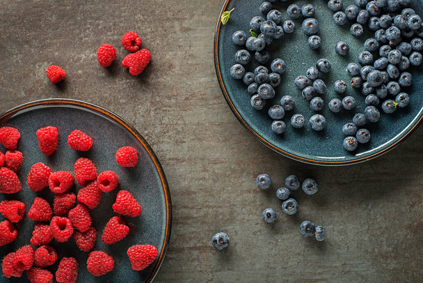 Colorful assorted of blueberry and raspberry. Berries overhead closeup - 写真・画像