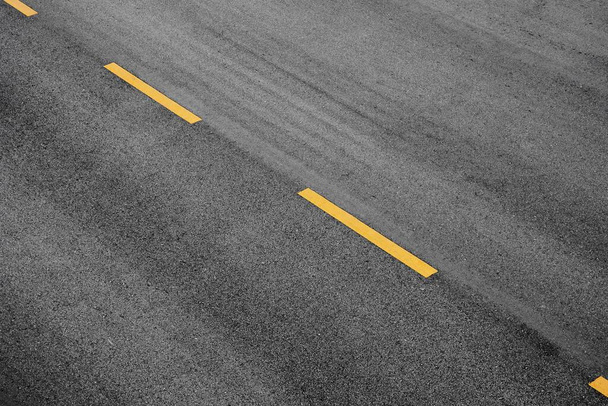 Yellow paint line on black asphalt. space transportation background - Photo, Image